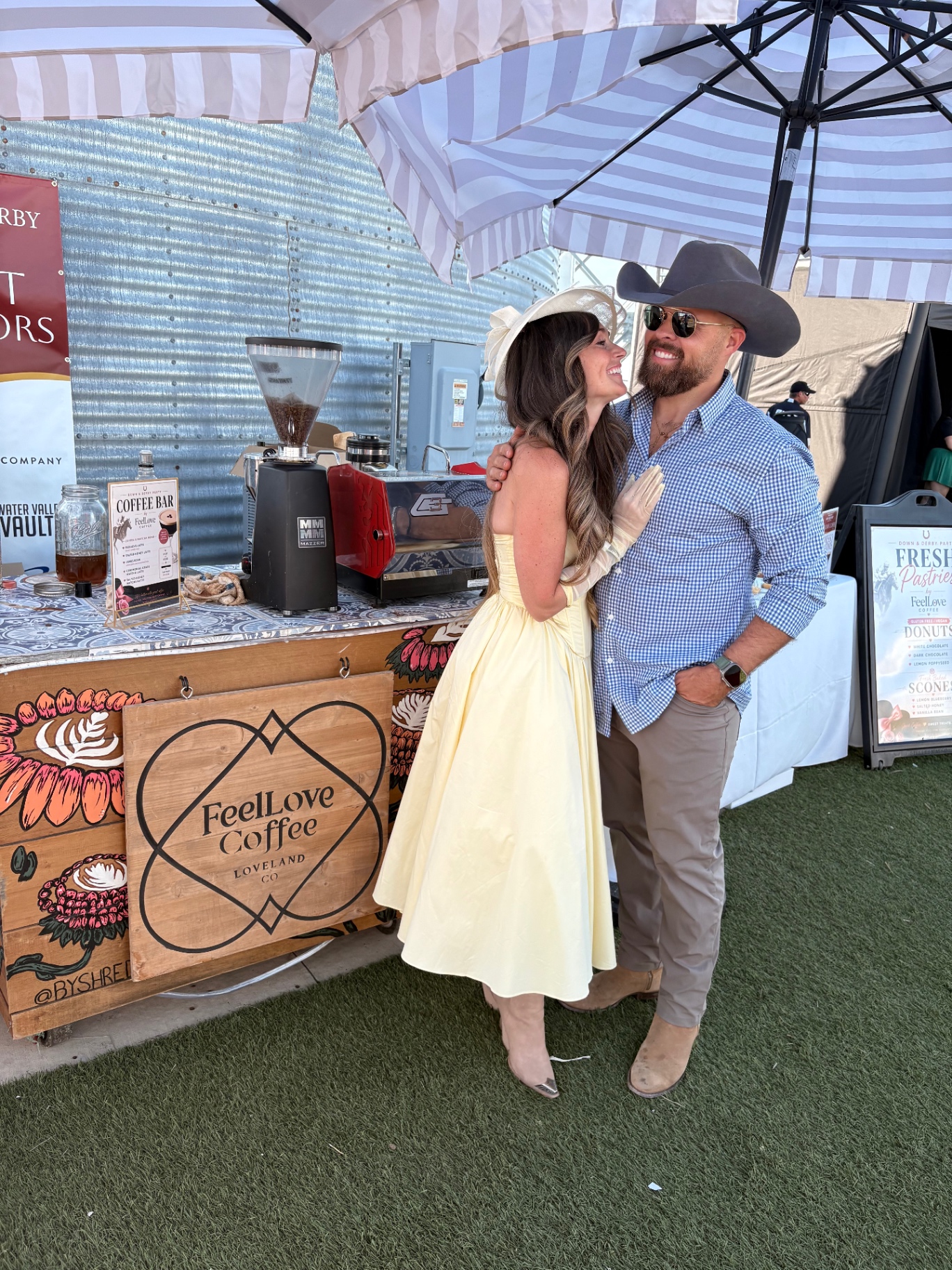 Tanner and Snowee Wood standing in front of the FeelLove Coffee cart at an outdoor event in Loveland, Colorado.